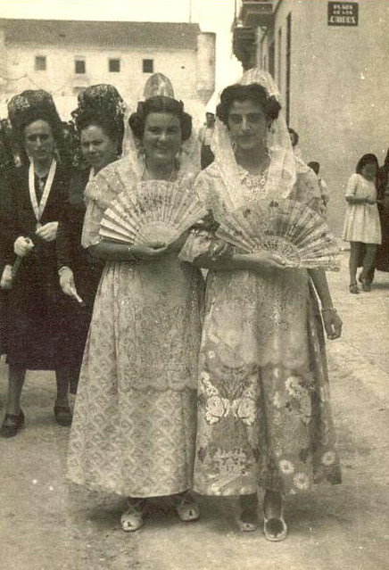 Mujeres vestidas con el traje regional antes de la procesión. Al fondo la desaparecida Casa Gran.