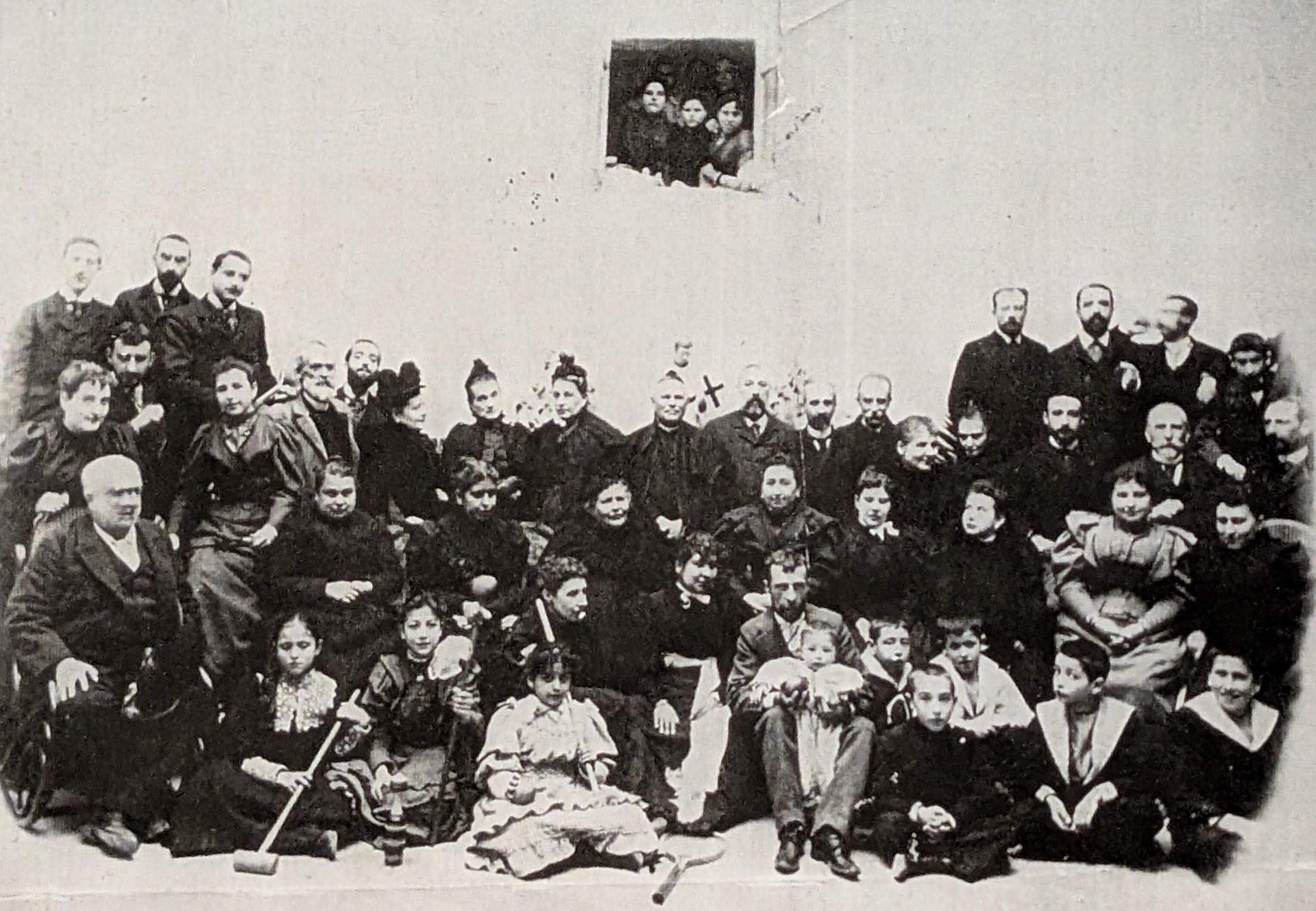 Reunión de la familia Llano y numerosas personalidades, entre ellas el párroco Martí Gadea, situado en el centro. Al fondo se aprecia la pequeña imagen de San Luis Gonzaga, a quien estaban dedicadas la capilla y la casa.